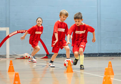 Children playing football in Little Kickers class