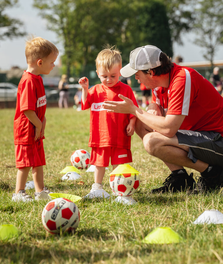 a person and two children playing football